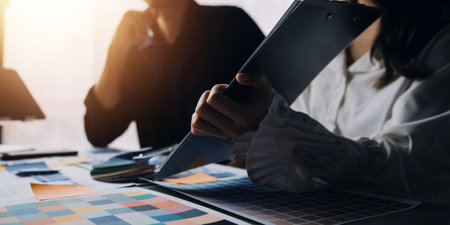Close up ux developer and ui designer brainstorming about mobile app interface wireframe design on table with customer breif and color code at modern office.Creative digital development agencyの写真素材