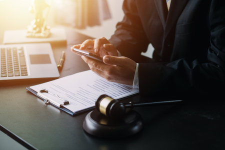 Justice and Law concept. Legal counsel presents to the client a signed contract with gavel and legal law or legal having team meeting at law firm in backgroundの写真素材