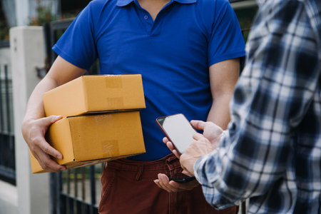 Startup SME small business entrepreneur of freelance Asian woman wearing apron using laptop and box to receive and review orders online to prepare to pack sell to customers, online sme business ideas.の写真素材