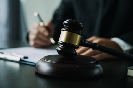 Justice and Law concept. Legal counsel presents to the client a signed contract with gavel and legal law or legal having team meeting at law firm in backgroundの写真素材