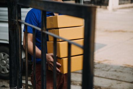 Startup SME small business entrepreneur of freelance Asian woman wearing apron using laptop and box to receive and review orders online to prepare to pack sell to customers, online sme business ideas.の写真素材