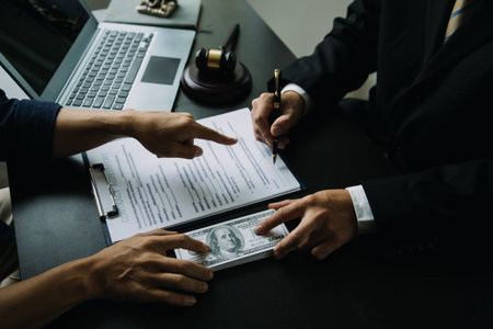 Justice and Law concept. Legal counsel presents to the client a signed contract with gavel and legal law or legal having team meeting at law firm in backgroundの写真素材