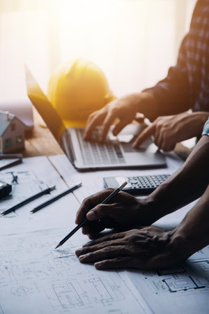 Image of engineering objects on workplace with three partners interacting on background
