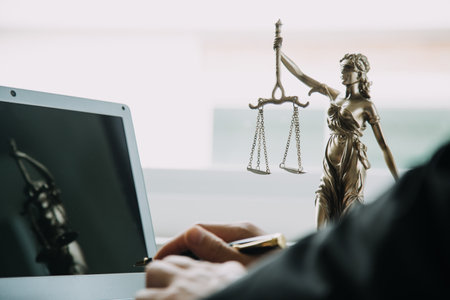 Justice and Law concept. Legal counsel presents to the client a signed contract with gavel and legal law or legal having team meeting at law firm in backgroundの写真素材