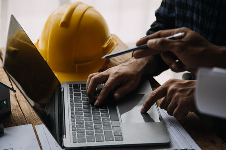 Image of engineering objects on workplace with three partners interacting on background