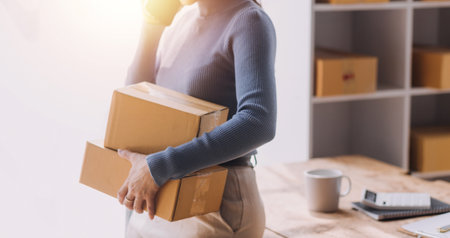 Entrepreneurs Small Business SME Independent men work at home Use smartphones and laptops for commercial checking, online marketing, packing boxes, SME sellers, concept, e-commerce team, online salesの写真素材