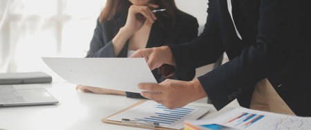 Business professionals. Group of young confident business people analyzing data using computer while spending time in the officeの写真素材