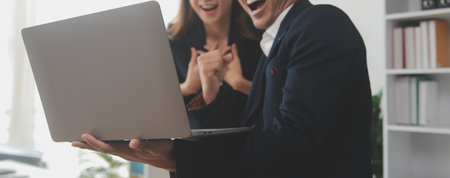 Business professionals. Group of young confident business people analyzing data using computer while spending time in the officeの写真素材
