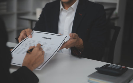 Close up view of job interview in office, focus on resume writing tips, employer reviewing good cv of prepared skilled applicant, recruiter considering application, hr manager making hiring decisionの写真素材