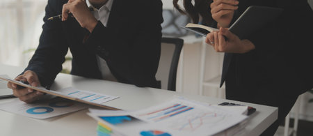 Business professionals. Group of young confident business people analyzing data using computer while spending time in the officeの写真素材