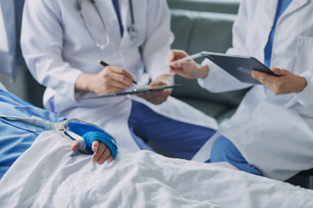Injured patient showing doctor broken wrist and arm with bandage in hospital office or emergency room. Sprain, stress fracture or repetitive strain injury in hand. Nurse helping customer. First aid.の写真素材