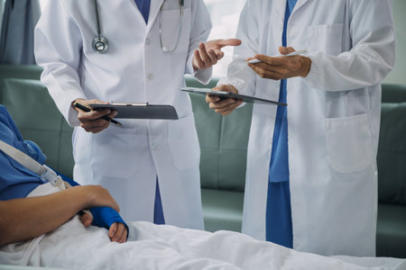 Injured patient showing doctor broken wrist and arm with bandage in hospital office or emergency room. Sprain, stress fracture or repetitive strain injury in hand. Nurse helping customer. First aid.の写真素材