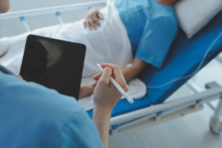 Women Asian doctors hold the patient hand and encourage and provide medical advice While checking the patient health in bed. Concept of Care and compassion, antenatal care, Threatened abortionの写真素材