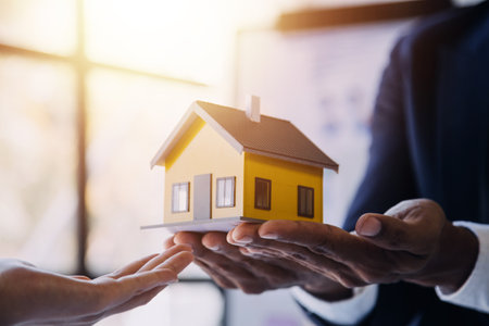 Real estate brokerage agent Deliver a sample of a model house to the customer, mortgage loan agreement Making lease and buying a house And contract home insurance conceptの写真素材