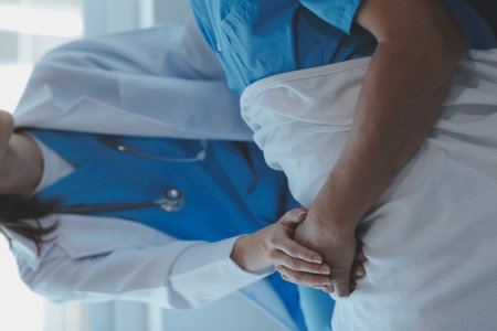 Injured patient showing doctor broken wrist and arm with bandage in hospital office or emergency room. Sprain, stress fracture or repetitive strain injury in hand. Nurse helping customer. First aid.の写真素材