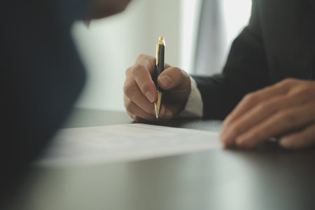 Justice and Law concept. Legal counsel presents to the client a signed contract with gavel and legal law or legal having team meeting at law firm in backgroundの写真素材