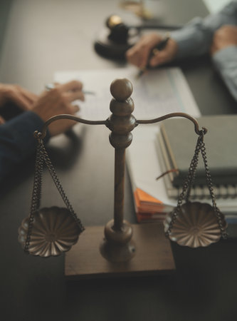 Justice and Law concept. Legal counsel presents to the client a signed contract with gavel and legal law or legal having team meeting at law firm in backgroundの写真素材