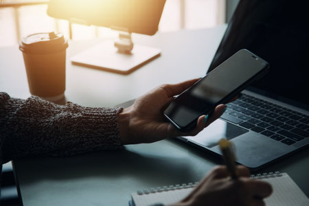 Financial analysts analyze business financial reports on a digital tablet planning investment project during a discussion at a meeting of corporate showing the results of their successful teamwork.の写真素材
