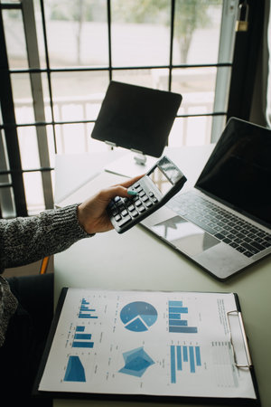 Financial analysts analyze business financial reports on a digital tablet planning investment...