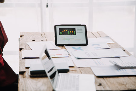 Financial analysts analyze business financial reports on a digital tablet planning investment...