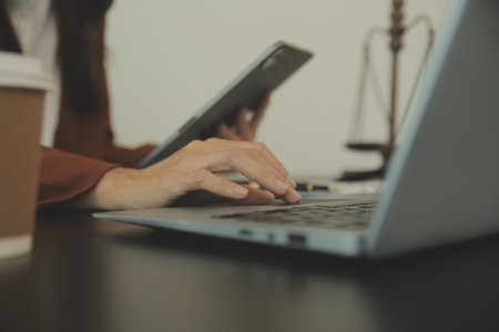 Justice and Law concept. Legal counsel presents to the client a signed contract with gavel and legal law or legal having team meeting at law firm in backgroundの写真素材