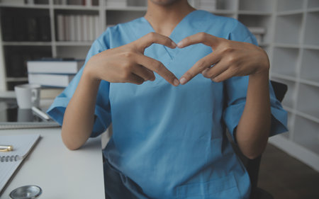 Male doctor standing with thumbs up sign in clinic near his working place. Perfect medical service in hospital. Medicine and healthcare conceptの写真素材