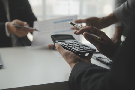 Financial analysts analyze business financial reports on a digital tablet planning investment project during a discussion at a meeting of corporate showing the results of their successful teamwork.の写真素材