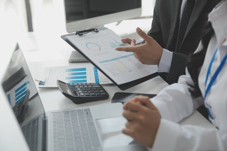 Asian Businesswoman Using laptop computer and working at office with calculator document on desk, doing planning analyzing the financial report, business plan investment, finance analysis concept.の写真素材