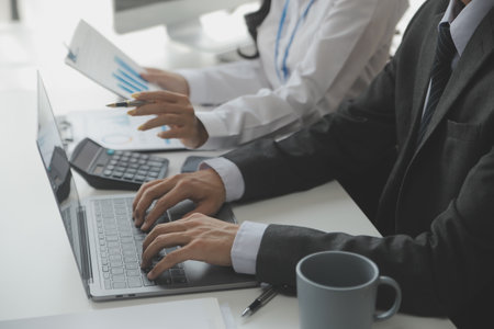 Asian Businesswoman Using laptop computer and working at office with calculator document on desk,...