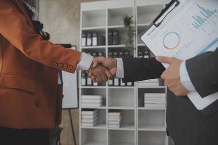Asian Businesswoman Using laptop computer and working at office with calculator document on desk, doing planning analyzing the financial report, business plan investment, finance analysis concept.の写真素材