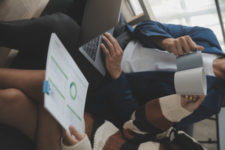 Asian Businesswoman Using laptop computer and working at office with calculator document on desk, doing planning analyzing the financial report, business plan investment, finance analysis concept.の写真素材