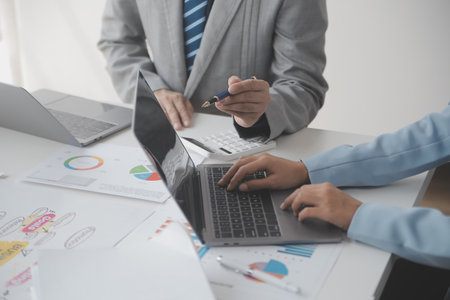 Financial analysts analyze business financial reports on a digital tablet planning investment project during a discussion at a meeting of corporate showing the results of their successful teamwork.の写真素材