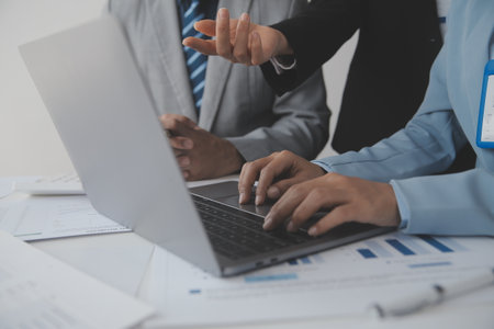 Financial analysts analyze business financial reports on a digital tablet planning investment project during a discussion at a meeting of corporate showing the results of their successful teamwork.の写真素材
