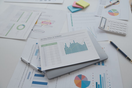 Financial analysts analyze business financial reports on a digital tablet planning investment project during a discussion at a meeting of corporate showing the results of their successful teamwork.の写真素材