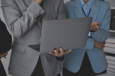 Financial analysts analyze business financial reports on a digital tablet planning investment project during a discussion at a meeting of corporate showing the results of their successful teamwork.の写真素材