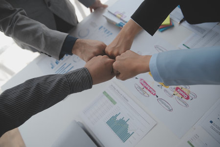 Financial analysts analyze business financial reports on a digital tablet planning investment project during a discussion at a meeting of corporate showing the results of their successful teamwork.の写真素材