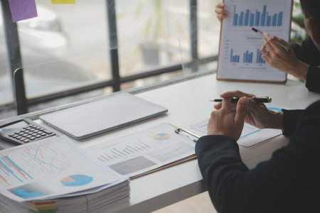 Financial analysts analyze business financial reports on a digital tablet planning investment...