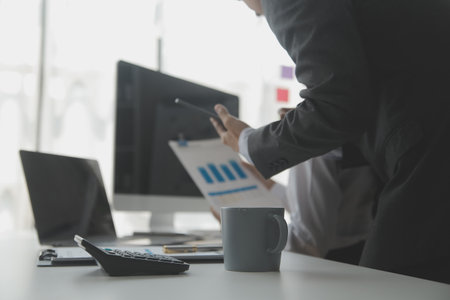 Group of confident business people point to graphs and charts to analyze market data, balance sheet,...