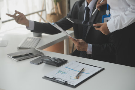 Group of confident business people point to graphs and charts to analyze market data, balance sheet, account, net profit to plan new sales strategies to increase production capacity.の写真素材