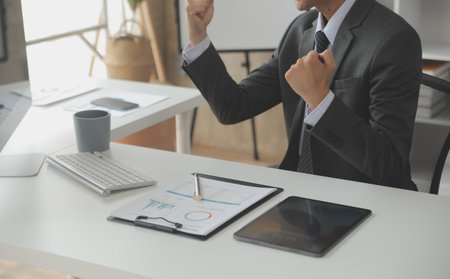 Group of confident business people point to graphs and charts to analyze market data, balance sheet, account, net profit to plan new sales strategies to increase production capacity.の写真素材