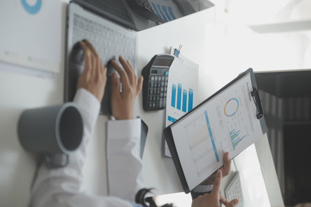 Group of confident business people point to graphs and charts to analyze market data, balance sheet, account, net profit to plan new sales strategies to increase production capacity.の写真素材