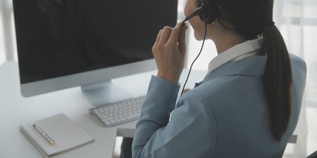 Young friendly operator woman agent with headsets working in a call centre.の写真素材