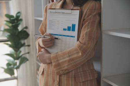 Financial analysts analyze business financial reports on a digital tablet planning investment project during a discussion at a meeting of corporate showing the results of their successful teamwork.の写真素材