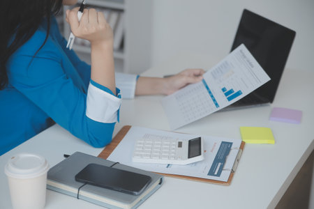 Financial analysts analyze business financial reports on a digital tablet planning investment project during a discussion at a meeting of corporate showing the results of their successful teamwork.の写真素材