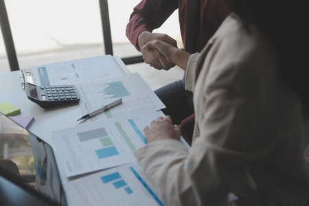 Financial analysts analyze business financial reports on a digital tablet planning investment project during a discussion at a meeting of corporate showing the results of their successful teamwork.の写真素材