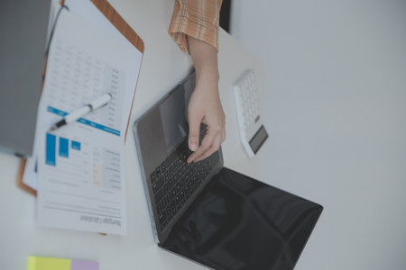 Financial analysts analyze business financial reports on a digital tablet planning investment project during a discussion at a meeting of corporate showing the results of their successful teamwork.の写真素材