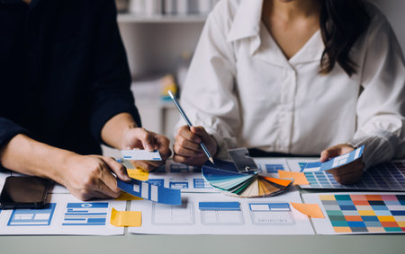 Close up ux developer and ui designer brainstorming about mobile app interface wireframe design on...