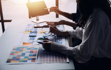 Close up ux developer and ui designer brainstorming about mobile app interface wireframe design on table with customer breif and color code at modern office.Creative digital development agencyの写真素材