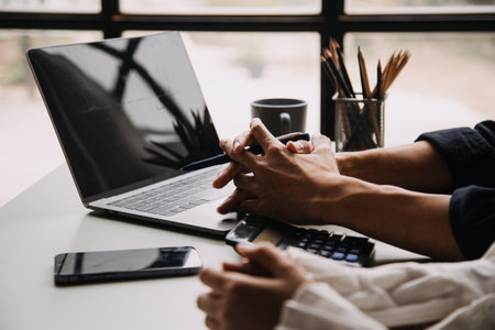 Entrepreneur Asian businessman and businesswoman discussing new business project in tablet in modern Meeting In Modern Office, Asian business casual concept.の写真素材