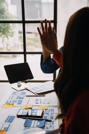 Close up ux developer and ui designer brainstorming about mobile app interface wireframe design on...